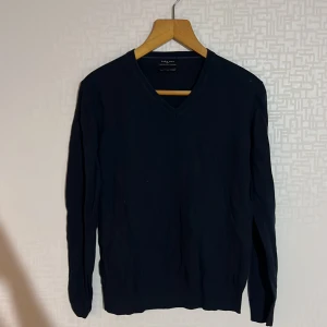 Mörkblå tröja från Zara Man - Säljer en stilren mörkblå tröja från Zara Man i en mjuk blandning av silke, bomull och kashmir. Tröjan har en v-ringad design och långa ärmar, perfekt för en elegant look.