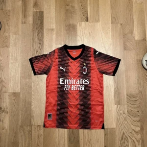 Ac milan home jersey - Hjälper en vän att sälja denna ac Milan home jersey årsmodel 23/24. Han är ungefär 172 cm lång och väger 56kg, den satt lite stort på han. Nu vill han sälja den eftersom han tyckte den satt så som han hade tänkt sig. Den är i väldigt bra skick