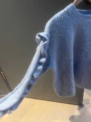Stickad tröja - Så fin stickad tröja från zara med volang detaljer på ärmarna. Tröjan är i en superfin ljusblå färg. Något nopprig men annars inga defekter 🩵