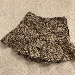 Leopardmönstrad kjol från Zara - Säljer en superfin leopardmönstrad kortkjol från Zara i storlek XS. Kjolen har volanger och en praktisk dragkedja på sidan. Kjolen har insydda ”shorts”! Knappt använd så toppskick  🐆✨