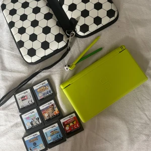 Nintendo DS Lite med fotbollsfodral - Säljer en cool limegrön Nintendo DS Lite med ett fotbollsmönstrat fodral. Perfekt för spelälskare! Inkluderar flera spelkassetter för timmar av underhållning. Fodralet har lite fläckar på sig så skriv för föer bilder. Använt sparsamt. Man får även med 7 spel ( syns på bilden) och en laddare😁😁