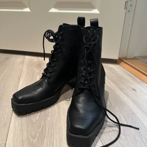 Svarta boots med snörning - Snygga svarta boots med snörning och dragkedja på sidan. De har en robust klack och en grov sula som ger bra grepp. Perfekta för höst och vinter, dessa boots är både stiliga och praktiska. Passar till både vardag och fest!
