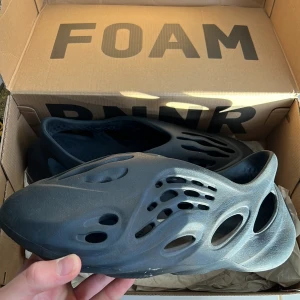 Svarta Foam RNNR - Säljer ett par svarta Foam RNNR i storlek 10 US. De är i nyskick och kommer i originalkartong. Perfekta för en avslappnad stil och superbekväma att ha på sig. Passar både för sommar och vår.