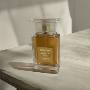 Tom Ford Vanilla Sex Eau de Parfum - Säljer en lyxig parfym från Tom Ford, Vanilla Sex, i en elegant glasflaska på 100 ml. Doften är varm och sensuell med en tydlig vaniljton. Perfekt för både dag och kväll. Flaskan har en stilren design med en fyrkantig form och en klar etikett. Passa på att köpa denna exklusiva doft!