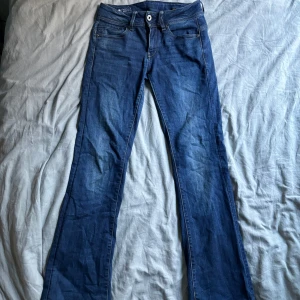 Lågmidjade bootcut jeans - Säljer dessa jättesnygga jeansen från G-star som tyvärr blivit för små. Står att storleken är 28/32 men passar en 26/30-32. Väldigt trendiga, slutsålda. Skit snygga!! Kom privat för mer bilder!!