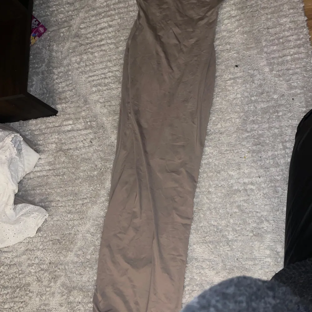 Säljer en snygg beige byxdress från Bershka i storlek XS. Den har smala axelband och är perfekt för både vardag och fest. Materialet är mjukt och bekvämt, vilket gör den idealisk för sommarens varma dagar. Passar perfekt med ett par sneakers eller klackar för en mer uppklädd look.. Klänningar.