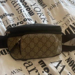Mönstrad gucci magväska - Snygg gucci magväska med klassiskt mönster och dragkedja. Perfekt för att bära med sig det viktigaste. Justerbart bälte för bekväm passform. Priset är inte fast går att diskutera vid snabb affär. Endast seriösa köpare, ingen bråttom att bli av med. 