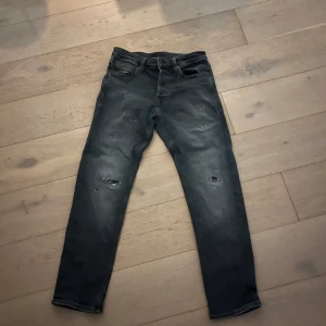Svarta jeans med slitningar - Snygga svarta jeans med slitningar för en trendig look. De har en klassisk femficksdesign och en bekväm passform. Perfekta för en avslappnad stil.
