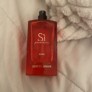 Si Passione Éclat från Giorgio Armani - Säljer en elegant parfymflaska av Si Passione Éclat från Giorgio Armani. Flaskan är i en djup röd färg. köpt för 1500 kan sälja för 500 då halva är kvar, ungefär 50 ml kvar 
