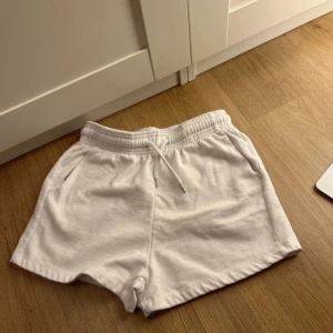 Vita bomullsshorts  - Säljer ett par vita bomullsshorts från Zara i storlek XS. De har en bekväm elastisk midja med dragsko och sidofickor. Perfekta för en avslappnad stil.