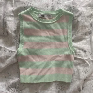 Randig ärmlös topp från Zara - Snygg ärmlös topp från Zara i pastellfärger. Den har breda ränder i ljusgrön och rosa och är croppad i modellen. Perfekt för en somrig look!