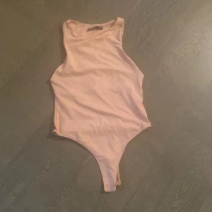 Beige ärmlös bodysuit från Zara - Säljer en stilren beige ärmlös bodysuit från Zara. Perfekt för lager-på-lager eller att bära som den är. Tillverkad i ett mjukt och bekvämt material.