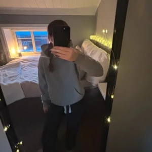 Grå hoodie - Säljer en klassisk grå hoodie. Perfekt för en avslappnad stil. Den har långa ärmar och ribbade muddar vid ärmslut och nederkant.