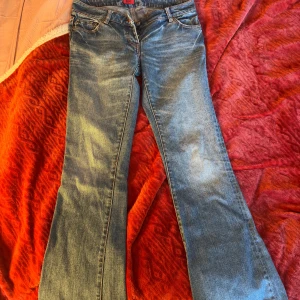 Blå jeans från Hugo Boss - Snygga blå jeans från Hugo Boss med knappstängning. Dem är bootcut och har snygga orangea sömmar. Säljer då dem tyvärr är för små för mig så inga bilder på. Midjemåttet 37 cm innerbenslängd 77-78 cm. 
