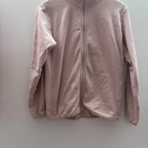 Beige fleecejacka från McKinley - Mysig beige fleecejacka från McKinley med dragkedja framtill. Perfekt för kyliga dagar med sin mjuka och varma känsla. Jackan har långa ärmar och en enkel design som passar till det mesta. Ett måste för garderoben!