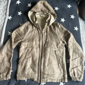 Vår cardigan från Massimo mutti  - Säljer en beige jacka med huva och dragkedja framtill. Jackan har långa ärmar och två fickor med dragkedjor. Perfekt för vår och höst. Luvan går att ta på och av och den passar perfekt till  våren. Den är i väldigt bra skick och har inga defekter. Ifall du har några funderingar är det bara att höra av sig!!!!