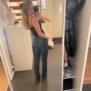 Blå jeans med bootcut - Snygga blå jeans med bootcut-stil och låg midja. Perfekta för en avslappnad look. Klassisk design med fem fickor och knappgylf. Lägger sig super snyggt över skorna! 