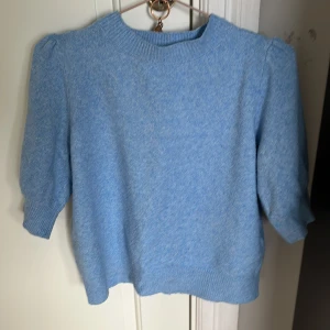 Ljusblå stickad tröja - Säljer en ljusblå stickad tröja med trekvartsärm och ribbade kanter. Perfekt för kyligare dagar och ger en mysig känsla. Passar bra till både jeans och kjol.