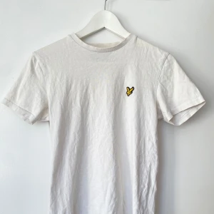 Lyle Scott tshirt - Säljer en  vit t-shirt från Lyle & Scott med en broderad gul logga på bröstet.