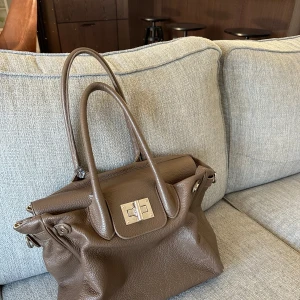 Brun väska i läder  - Säljer denna fina väska i grymt skick. Köpt second hand men den är ”genuine Leather” och Made in Italy 