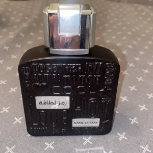 Ramz Lattafa Parfym - Snygg parfymflaska från Lattafa med texturerad yta och silverfärgad kork. Perfekt för den som vill ha en unik doftupplevelse. Luktar som jpg ultramale. Riktigt bra . Ca 85 ml kvar i flaskan