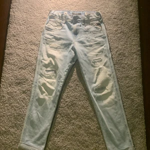 Ljusa jeans från Replay - Snygga ljusa jeans från Replay med slitna detaljer och en skinny passform. Perfekta för en trendig look. De har en klassisk femficksdesign och knappgylf.