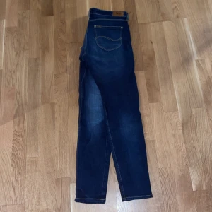 Mörkblå jeans Scarlett - Säljer ett par mörkblå jeans av modellen Scarlett. De har en klassisk femficksdesign och är tillverkade i ett stretchigt material för extra komfort. Perfekta för en stilren look.nypris 1099kr