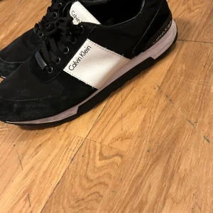 Svarta och vita sneakers - Snygga sneakers  i svart och vitt. Skorna har en klassisk design med snörning och en bekväm sula. Perfekta för en stilren look. Fa*e