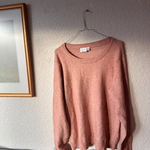 Rosa stickad tröja från Gina Tricot - Mysig rosa stickad tröja från VILA  med rund halsringning och långa ärmar. Perfekt för kyliga dagar och enkel att matcha med olika outfits.