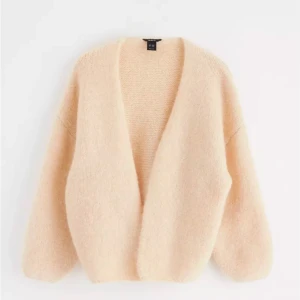 Beige fluffig kofta - Supermysig beige kofta i fluffigt material, perfekt för kyliga dagar. Den har en lös passform och långa ärmar, vilket gör den idealisk för lager-på-lager. Koftan är öppen framtill och kan stylas med ett bälte för en mer definierad look. Ett måste för höstgarderoben!  Efterfrågad och slut på hemsidan i alla färger! Fråga om egna bilder vid fundering, sitter superfint på! Prislapp kvar!