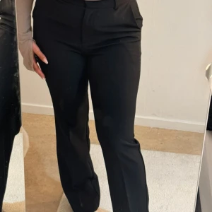 Svarta kostymbyxor - Snygga svarta kostymbyxor med hög midja och rak passform. Perfekta för en stilren look.