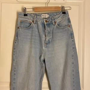 Ljusblå jeans från NA-KD - Snygga ljusblå jeans från NA-KD med hög midja och rak passform. Sönder i fickan och byxhällorna bild 3!