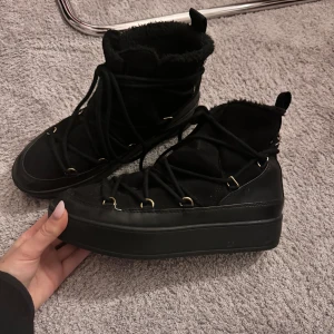 Svarta inukki liknande skor  - Säljer ett par svarta inukki liknande skor i storlek 39, från attitude. Fint skick 