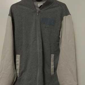  jacka från Nike - Säljer en snygg jacka från Nike. Ganska ny, Dena modellen finns inte längre. Den har Nike-logotyp både på bröstet och ryggen. Jackan är perfekt för en casual look och är superbekväm. Passar perfekt för höst och vintern.