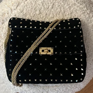 Valentino garavani rockstud spike bag - Säljer min fina väska i mycket bra skick. Det ända är lite materialslitage på baksidan som stans på bilderna, men inget som stör. Väskan är i sammet/suede material och är mjukare än de vanliga med skinn. Alla nitar finns kvar! Äkthetsbevis från vestiaire collevtive medföljer samt dustbag och kort. Skriv för fler bilder på väskan 