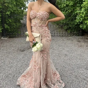 Balklänning - Elegant axelbandslös långklänning i en ljus beige ton med vackra blommiga detaljer. Klänningen är perfekt för bröllop eller bal 💗använt bara en gång, helt ny