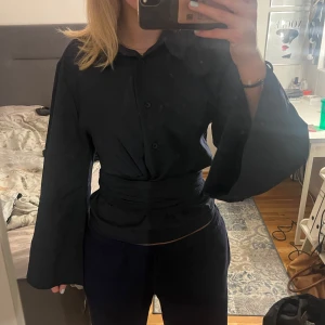 Mörkblå blus med knytband - Snygg marinblå blus med unikt knytband i midjan. Den har en fin passform som framhäver din midja och vida ärmar som ger en cool och avslappnad look. Perfekt för både vardag och fest! Den är helt ny och har prislappen kvar, hör gärna av dig om du vill ha fler bilder!💗💗