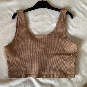 Beige ribbad linnetopp från Gina Tricot - Säljer en snygg beige ribbad linnetopp från Gina Tricot i storlek L. Perfekt för sommardagar eller som ett lager under en jacka. Toppen är i mycket bra skick och har en skön passform. Passar till både vardag och fest!