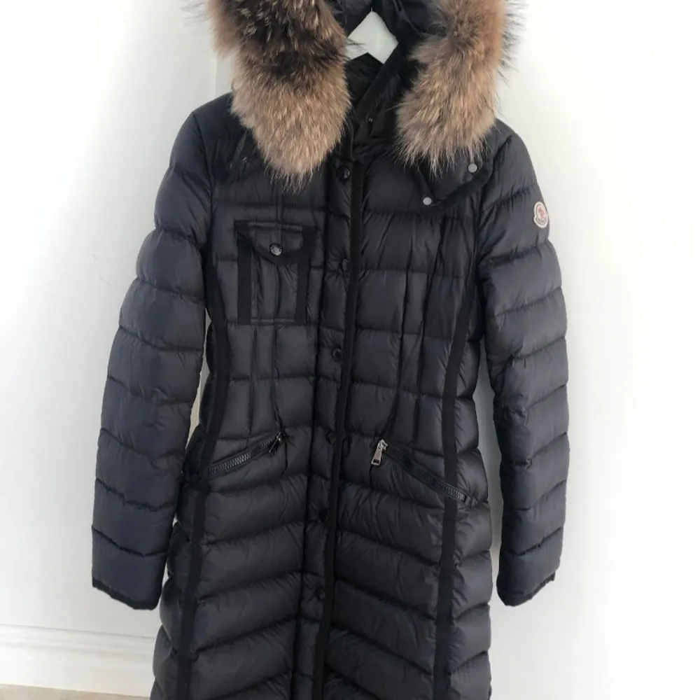 Snygg svart dunjacka från Moncler med pälsdetalj på huvan. Jackan har en quiltad design och långa ärmar. Perfekt för kalla vinterdagar med sin varma och stilrena look. Jag har fortfarande det fysiska orginalkvittot från Olséns som följer med. Jackan är i otroligt bra skick! . Takit.