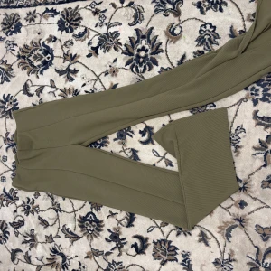 Olivgröna byxor från H&M - Säljer ett par olivgröna byxor från H&M i storlek S. De är utsvängda passform och är perfekta för både vardag och fest. Byxorna är tillverkade i ett mjukt och bekvämt material, vilket gör dem sköna att bära hela dagen. Perfekta för höst och vår! Ass snyggt med vit stickad tröja 