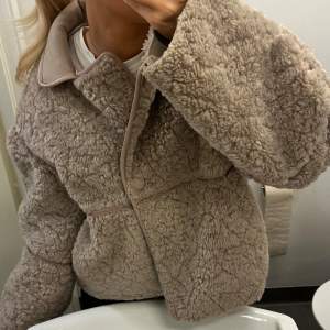 Supermysig beige teddyjacka från H&M i storlek XS. Perfekt för höst och vinter med sin fluffiga och varma design. Jackan har en oversized passform och stängs med knappar framtill.      Varm och stilren!