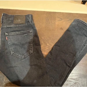 Svarta jeans från Levi's - Säljer ett par klassiska svarta Levi's jeans i bra skick. De har en normal passform och är perfekta för både vardag och fest. Jeansen är tillverkade i slitstarkt denim och har den ikoniska Levi's-lappen på baksidan. Perfekta för höst och vinter!