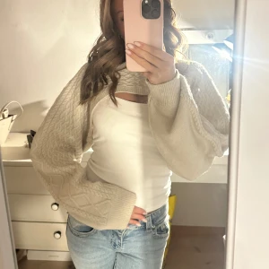 Beige stickad bolerotopp - Säljer en mysig beige stickad bolerotopp med kabelstickat mönster. .