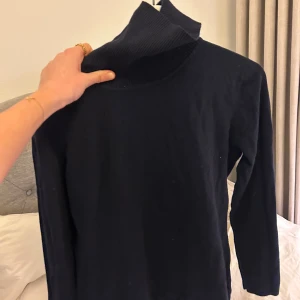 Mörkblå/marinblå polotröja - Säljer en stilren mörkblå, nästan svart polotröja med långa ärmar. Perfekt nu till vintern och enkel att matcha med olika outfits. Tröjan har en klassisk design med ribbad krage. Perfekt att klä upp och klä ner. 💕💕 Kontakta mig vid fler frågor. 😇😇