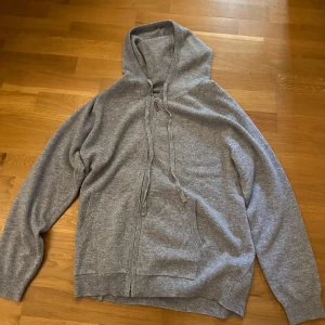 Grå kashmir hoodie med dragkedja - Säljer en stilren grå kashmir hoodie med dragkedja och justerbar huva.  Den är väldigt bekväm och skön.