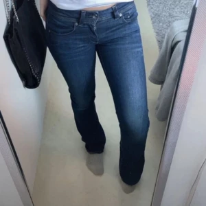 Lågmidjade jeans  - Säljer ett par snygga mörkblå bootcut jeans från G-Star RAW i storlek 24/34. De har en klassisk femficksdesign och är i mycket bra skick. Perfekta för både vardag och fest! 