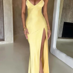 Gul långklänning med öppen rygg - Säljer en fantastisk gul långklänning i satin med en elegant slits och öppen rygg. Klänningen har smala axelband som korsas i ryggen och ger en snygg snörningsdetalj. Perfekt för sommarens fester eller en speciell kväll. Den är i nytt skick och inte använd💛