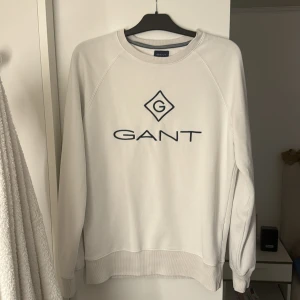 Vit sweatshirt från GANT - Säljer en stilren vit sweatshirt från GANT, har använt den 3 - 5 gånger och väljer nu att sälja den. Den är i mycket bra skick.