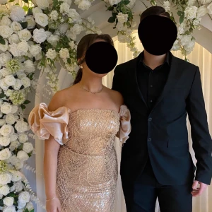 Säljer min fina festklänning  - Elegant glittrig klänning i guld med puffiga ärmar ,Klänningen har en åtsittande passform och är perfekt för festliga tillfällen. Endast använd ett par timmar,priset går att diskutera?