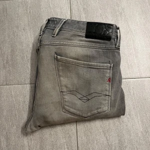 GRÅ REPLAY ANBASS JEANS - Säljer ett par snygga grå jeans från Replay i modellen Anbass. De har en slim passform och är i mycket bra skick. Storlek 34 | modellen är 181 cm och väger 76 kg | säljs nu för endast 399kr!